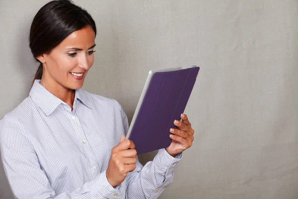 Smiling businesswoman holding and reading tablet — Φωτογραφία Αρχείου