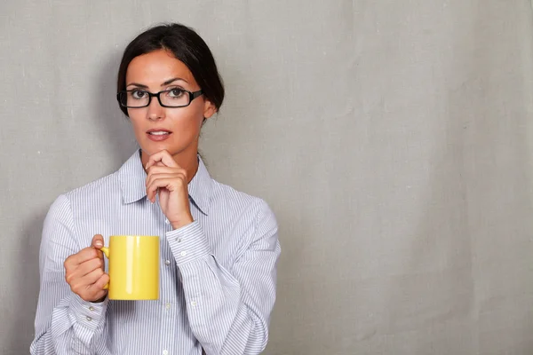 Thinking businesswoman with cup of drink — 图库照片