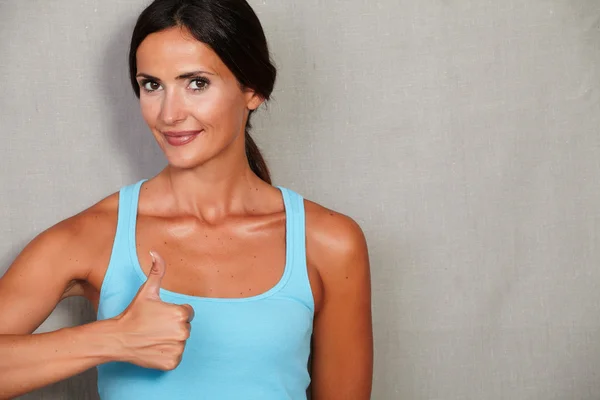 Fitness lady showing thumb up — Stockfoto