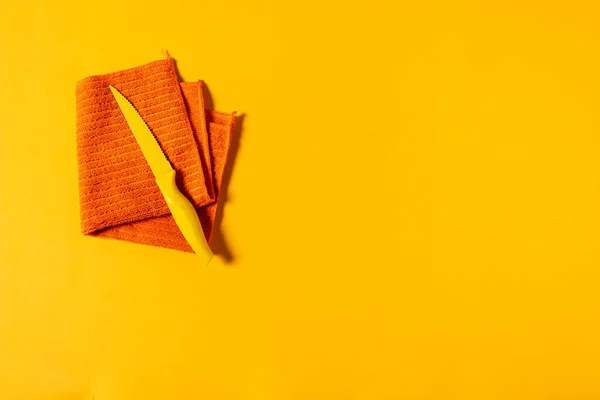 Pomarańczowe Naczynie Złożone Małym Żółtym Nożem Żółtym Tle — Zdjęcie stockowe