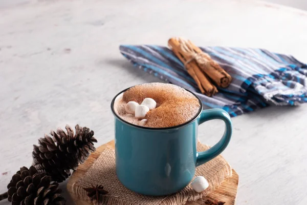 Blue mug with hot cocoa drink and mash mellows laid on vintage table