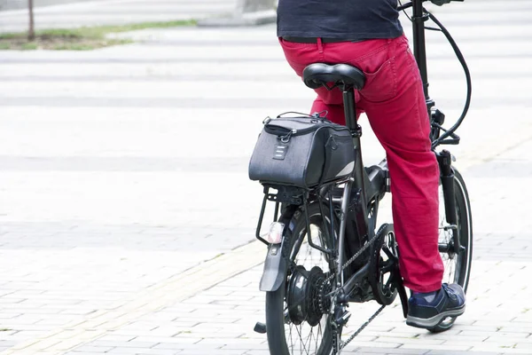 黒いシャツに赤いパンツを着た男がメデジンの通りを電動自転車に乗って ストック画像