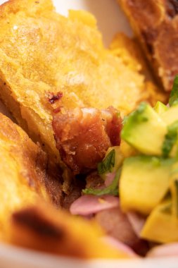 Medellin Kolombiya 'dan geleneksel bir yemekle arka planda kızarmış muz ile bir parça domuz eti.