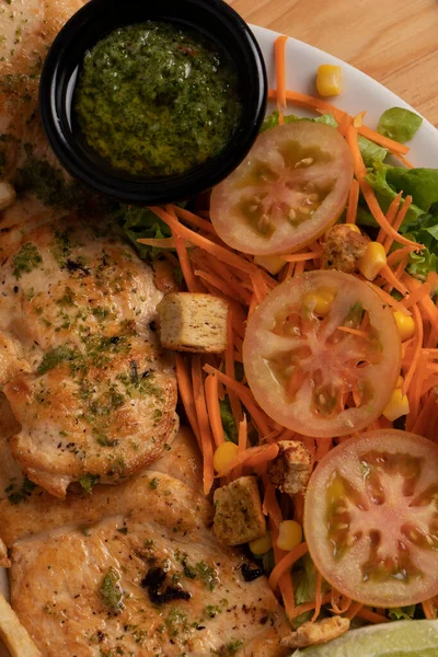 Geleneksel Kolombiya yemek tabağı ızgara tavuk fileto salata ve patates kızartması.