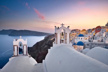 Kilisenin çan kulesiyle Santorini 'de gün batımının fotoğrafı.