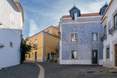 Cascais 'deki yaya caddesinde geleneksel sarı Portekiz evi ve Rua dos Navegantes boyunca mavi fayans cephesi bulunuyor..