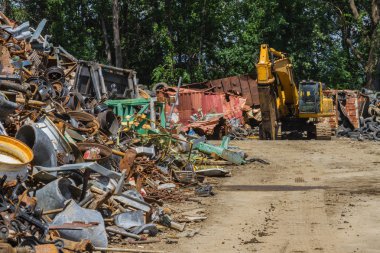 Farklı paslı nesneleri ve adet dolu bir hurda avlusunda Hidrolik Ekipmanları