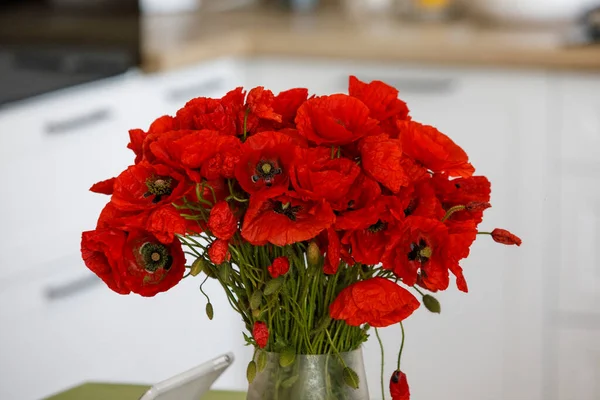 red poppies flowers in a vase on the table. High quality photo