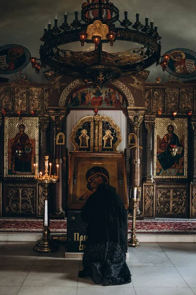 Monge ajoelhado na frente do ícone da igreja — Fotografia de Stock
