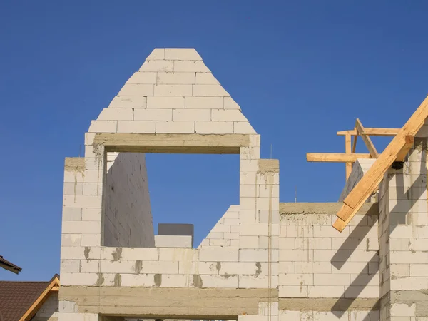 Gökyüzünün arka planına karşı beyaz tuğlalı ya da köpük bloklu küçük bir ev.