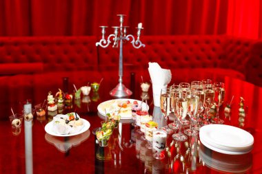 Kızarmış ekmekler, atıştırmalıklar ve kırmızı tonlarda tatlılarla dolu açık büfe masası.