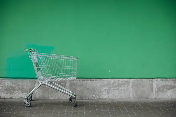 Keranjang supermarket dan dinding hijau — Stok Foto