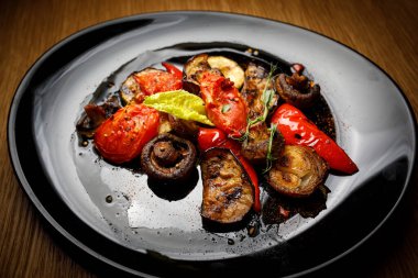 Siyah bir tabakta ızgara sebze.