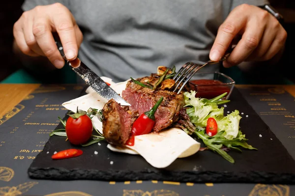 Tahtada biftek, restoranda et eli.