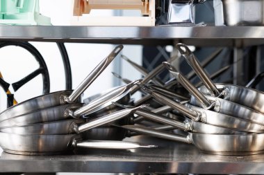 Stacked metal frying pans arranged in two stacks. High quality photo