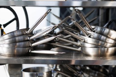 Stacked metal frying pans arranged in two stacks. High quality photo