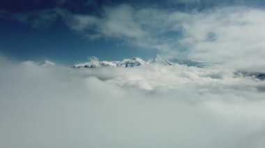 Bulutların üzerinden hava manzarası. Rosa Khutor Ski Resort, Rusya 'da Krasnaya Polyana' da karla kaplı dağlar.