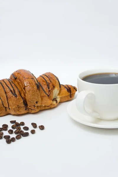 Top view or flat lay of coffee cup and croissant on white background with copy space. Morning coffee and snack.