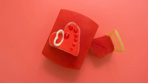Üzerinde beyaz çikolata kalp olan çikolatalı kek, pembe arka planda mesaj için yer var. Sandalyedeki oyuncak masasında pasta. Sevgililer günü, kartpostal.