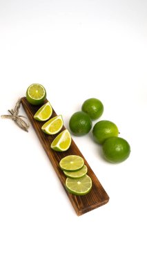 Beyaz arka plandaki ahşap mutfak tahtasına dilimlenmiş taze limon. İçki ya da yemek hazırlama konseptinin hazırlanması. İzole et.