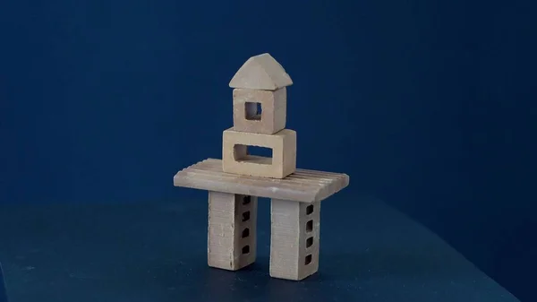 The building was built of mud bricks. Details of the constructor. Clay product. Creative set. Child Game. Architectural solution. House on a dark background. Rotation of the object.
