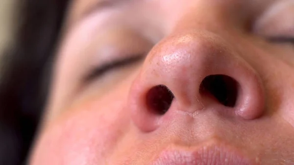 Nasal breathing. Woman\'s face. Movement of the nostrils. Inhalation of air. Part of the face. Big nose. A sick man. Oxygen breathing. Macro. Close-up.