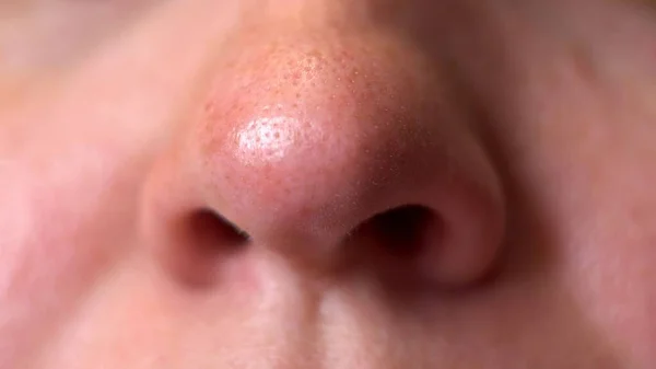 Nasal breathing. Woman\'s face. Movement of the nostrils. Inhalation of air. Part of the face. Big nose. A sick man. Oxygen breathing. Macro. Close-up.