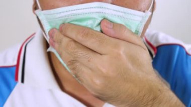 Hijyenik maske takan erkekler beyaz arka planda yeni grip virüsü yüzünden öksürüyorlar. Tıbbi sağlık hizmeti konsepti. Coronavirus ya da SARS grip salgını insan sağlığı ciddi sendromu. 4K