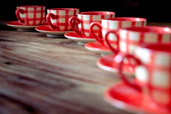 Primo piano di tazze di caffè rosso colorato sul tavolo di legno — Foto Stock