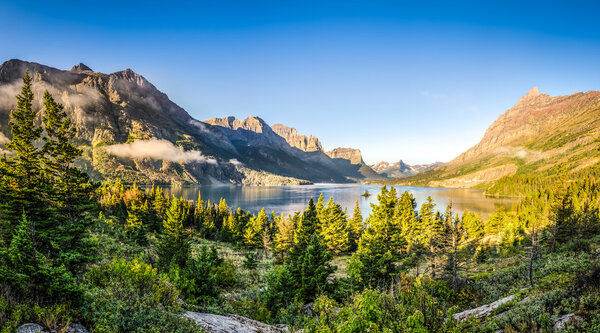 Panoramic landscape view of Glacier NP mountain range and lake