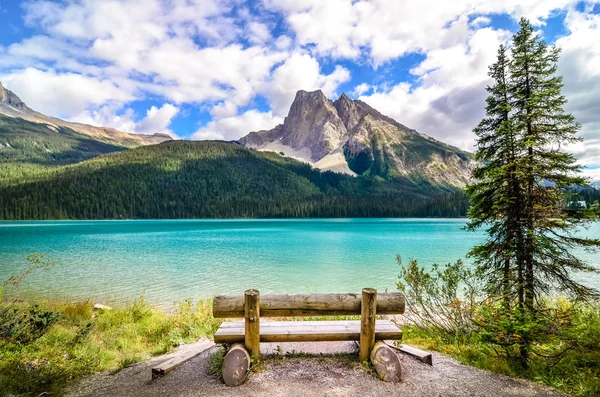 Scenic view of mountain lake and wooden bench — Stock Photo, Image