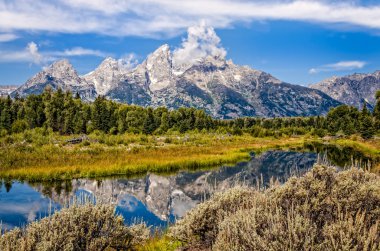 Su yansıması ile Grand Teton Dağları'nın doğal görünümü
