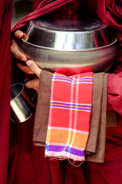 Cierre de manos de monje budista sosteniendo un tazón y una taza — Foto de Stock