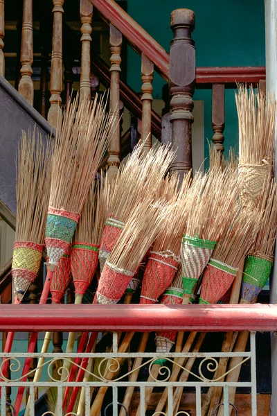 Detail of colorful rustic brooms in wooden stairway — Stock Photo, Image