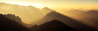 Panoramic scenic view of mountains and hills silhouette at sunse