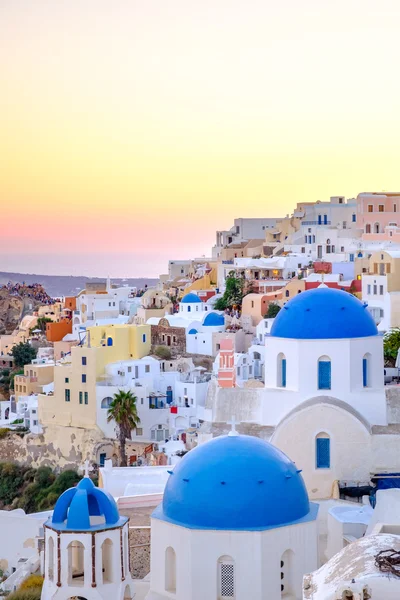 Vista panorâmica de casas coloridas e cúpulas azuis ao pôr do sol — Fotografia de Stock