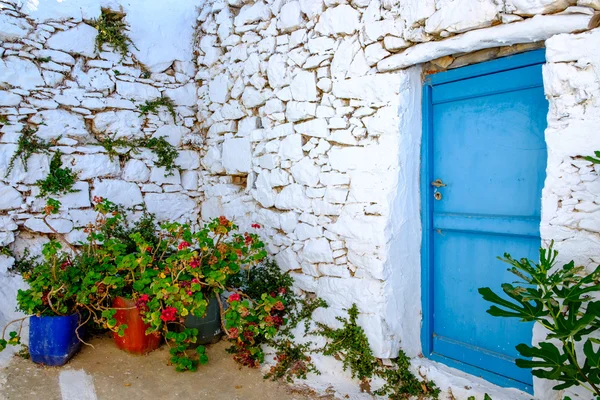 Dettaglio porta blu, muro in pietra bianca e fiori colorati — Foto Stock