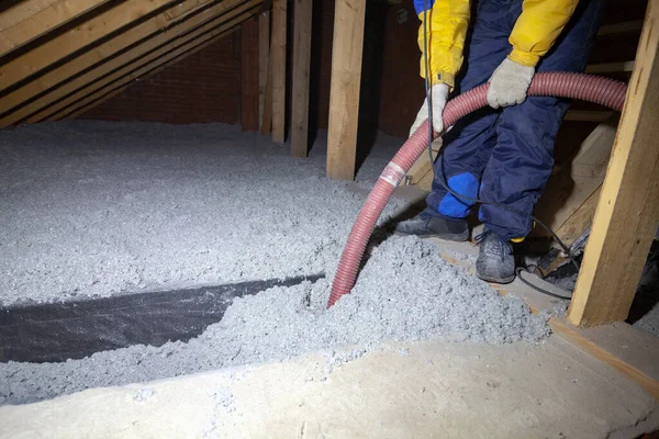 Spraying cellulose insulation in the attic of a house. Insulation of the attic or floor in the house — Stock Photo, Image