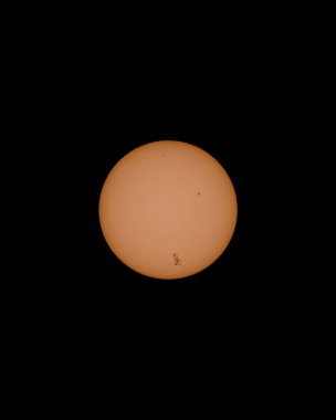 Karanlık bir boşluğa karşı güneş yumuşak bir şekilde parlar. Yüzey aktif güneş lekeleri gösteriyor. Güneş, kozmik, astronomik, doğa.