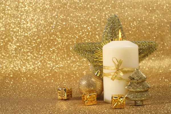 Schöne Weihnachtskerze auf goldenem Glitzerhintergrund mit Kopierraum — Stockfoto