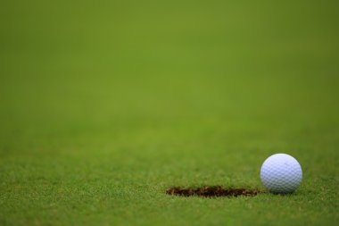 Golf ball on lip of cup