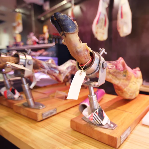 Traditionella spanska jamon ben på showcase i butik — Stockfoto