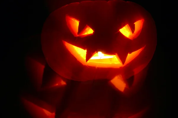 Beleuchtete niedliche Halloween-Kürbis isoliert auf schwarzem Hintergrund — Stockfoto