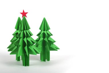Beyaz arka planda izole edilmiş yeşil el sanatları kağıdından Origami Noel ağaçları