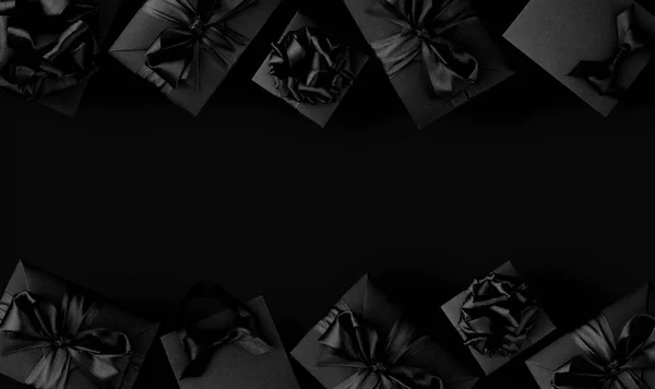 Black shopping bags and gift boxes on black background with copy space for text, Black Friday sale shopping concept