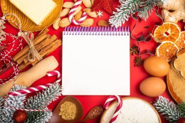 Noel kurabiyeleri arka planda düz görünüm şablonu ve metin için fotokopi alanı oluşturuyordu. Kırmızı kağıt üzerinde mutfak gereçleri, baharatlar ve yiyecek malzemeleri.