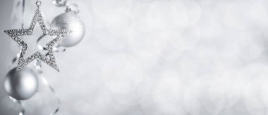 Gümüş Noel yeni yıl baloları ve kıvrımlı flama kurdeleli yıldız ışıltılı Bokeh ışıkları arka planında metin alanı için fotokopi arkaplan