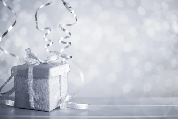 Ezüst Karácsony Újév Ajándék Göndör Szalagszalaggal Felett Csillogó Bokeh Fények — Stock Fotó
