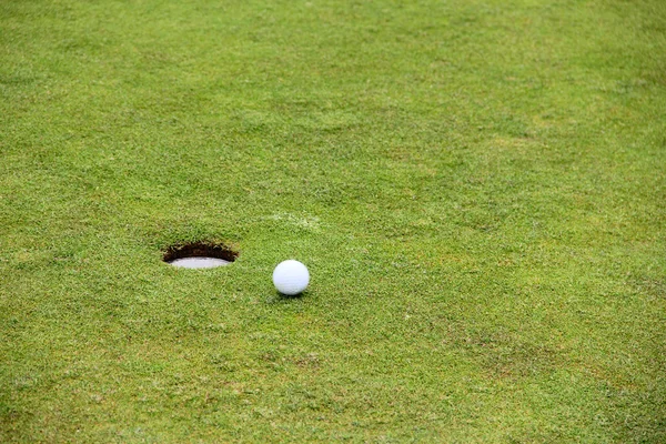 Golf ball op lip van cup — Stockfoto