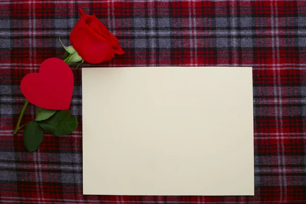 Rosa vermelha em tecido com papel em branco — Fotografia de Stock